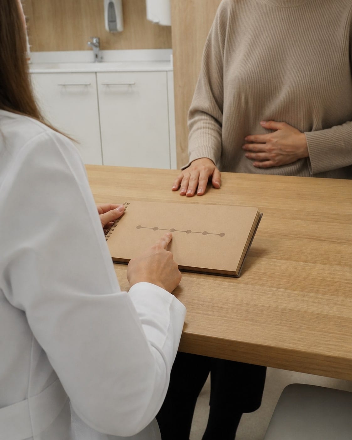 Consulta de salud digestiva con una nutricionista de bata blanca, sin mostrar su rostro