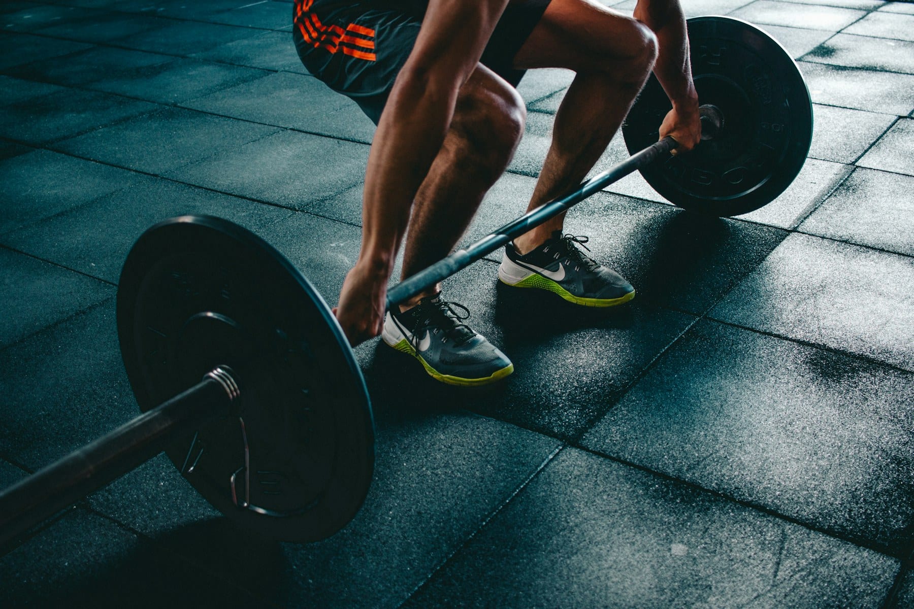 Persona entrenando fuerza con barra en un gimnasio, estímulo clave para preservar masa magra