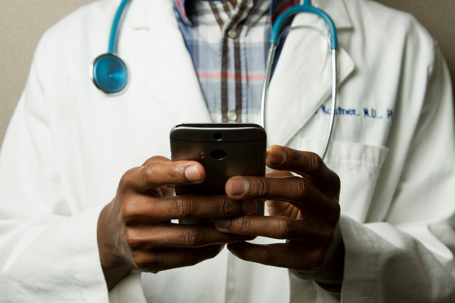 Médico traumatólogo en consulta explorando articulación de un paciente